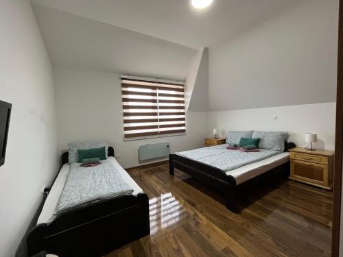 a bedroom with two beds and a window at Apartman Vuk Zlatar in Brdo