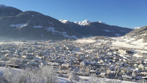 a town in the snow with mountains in the background at Stroblhof in Vipiteno