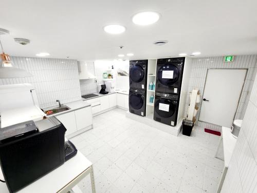 a kitchen with two washer and dryers in it at Friends Yul For men in Seoul