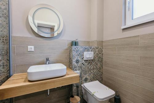 a bathroom with a sink and a mirror and a toilet at Pansion "Fawlty Towers" Sarajevo in Sarajevo