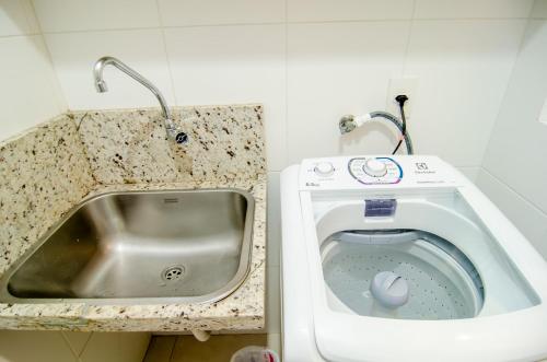 a washing machine in a kitchen next to a sink at Apto Vista Mar com acesso a Praia do Santinho QM9528 in Florianópolis