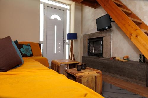 1 dormitorio con cama amarilla y chimenea en Olga's Cozy home, en Monemvasia
