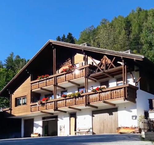 a building with a balcony with flowers on it at Stroblhof in Vipiteno