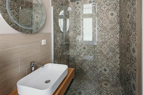 a bathroom with a white sink and a shower at Pansion "Fawlty Towers" Sarajevo in Sarajevo