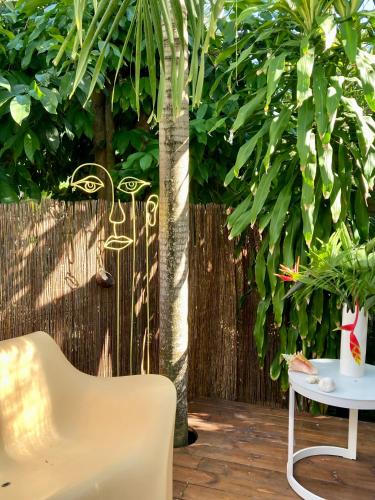 a chair and a table in front of a fence at 17 Les Palmes - Maison de charme - Piscine privée et accès plage in Sainte-Anne