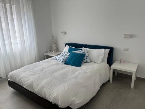 um quarto com uma cama grande e almofadas azuis e brancas em La Ritorna em Ortona