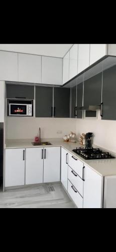 a kitchen with white cabinets and a stove top oven at إيفا شالية in Mu‘tamar