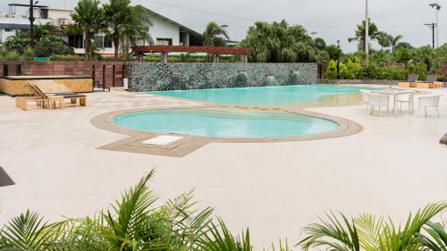 una piscina con mesa y sillas en un patio en Monk's Nirvanaa Hotel & Resort en Indore