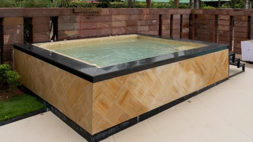 a large pool of water with a wooden frame at Monk's Nirvanaa Hotel & Resort in Indore