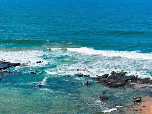 an aerial view of the ocean with waves and rocks at 101 Camarque - Beachfront Apartment in Umdloti