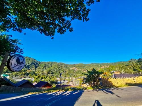 an empty street with a mountain in the background at ฟินอินดอย in Chom Thong