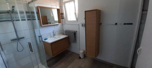 a bathroom with a shower and a sink and a mirror at Adorable maison dans le port in Port-Vendres