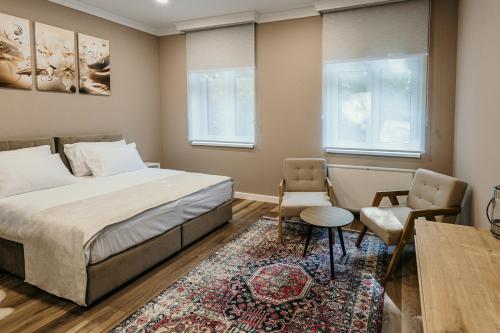 a bedroom with a bed and a table and chairs at Pansion "Fawlty Towers" Sarajevo in Sarajevo