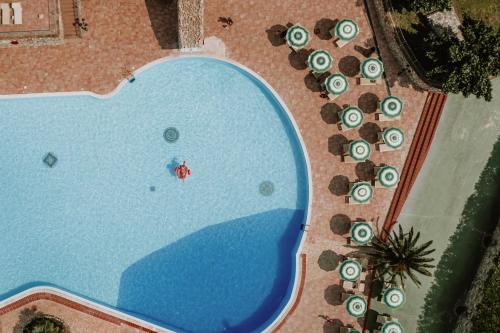an overhead view of a swimming pool with chaise lounges at Borgo San Pecoraio Resort in Riparbella