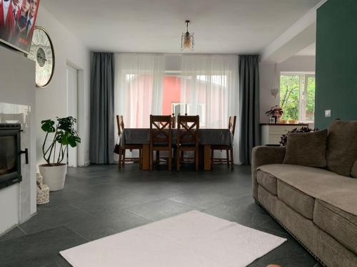 sala de estar con mesa y sofá en Casa individuala cu gradina en Botoşani