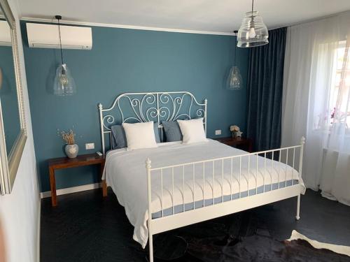 1 dormitorio con 1 cama con pared azul en Casa individuala cu gradina en Botoşani