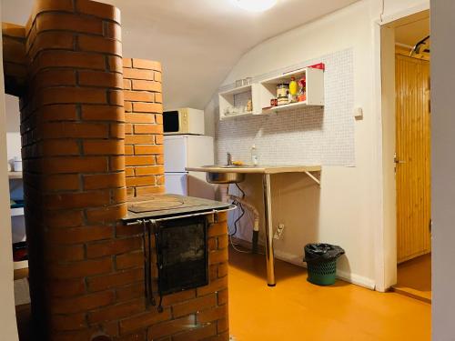 una cocina con una pared de ladrillo junto a una mesa en Stuudiokorter, en Tapa