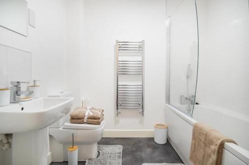 a bathroom with a sink and a toilet and a shower at Heathrow Haven: Stylish Apartments in the Heart of Slough in Slough