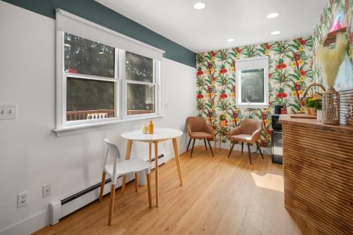 a dining room with a table and chairs and windows at Birches Motel in Saratoga Springs