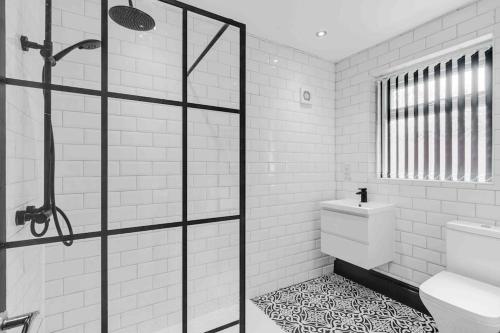 a black and white bathroom with a shower and a toilet at 4 bedroom stylish home central location in Liverpool