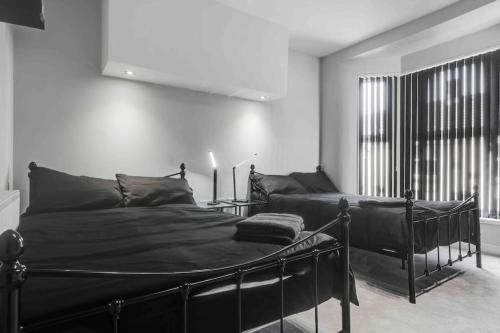 a bedroom with a black bed and a window at 4 bedroom stylish home central location in Liverpool