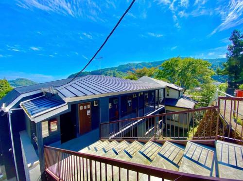 a blue house with a balcony with a view at 箱根湯本から一駅。大正〜昭和の家具に囲まれた、緑香るウッドテラスのある宿。高台から小田原の街を一望　 in Odawara