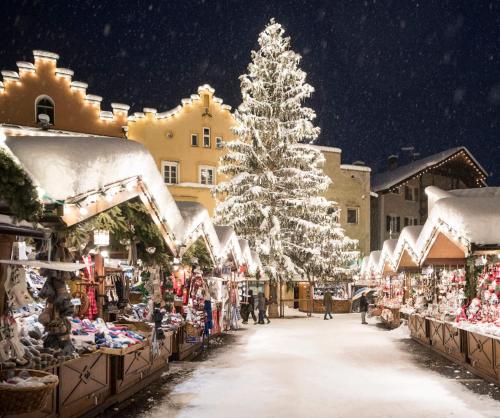 a christmas market in a town with a christmas tree at Stroblhof in Vipiteno