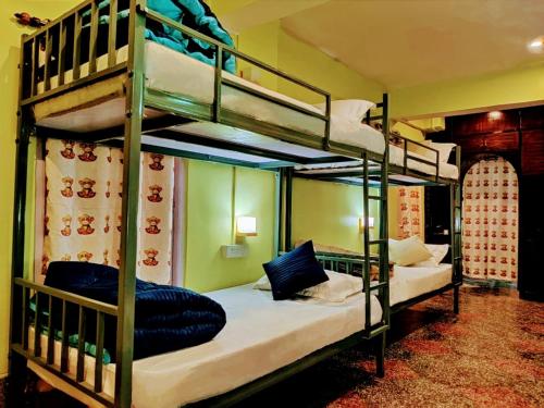 a bedroom with two bunk beds in a room at Hidden Monkey Hostels in Darjeeling