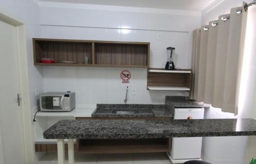 a kitchen with a counter top and a microwave at Lacqua diRoma com Parque Aquático e Cozinha in Caldas Novas