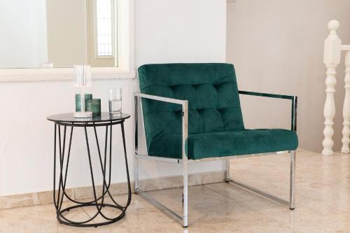 a green chair sitting next to a small table at Luxury Villa 6BR with Swimming Pool by Beach - Villa Costa in Rishon LeẔiyyon