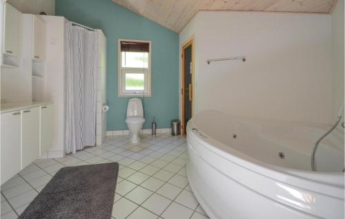 uma casa de banho com uma banheira e um WC. em Awesome Home In Glesborg With Kitchen em Fjellerup Strand