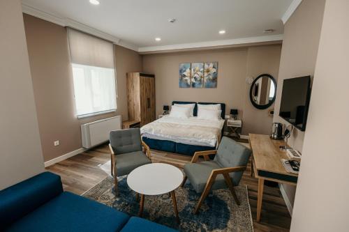 a hotel room with a bed and a table and chairs at Pansion "Fawlty Towers" Sarajevo in Sarajevo
