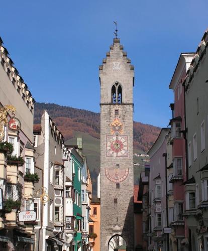a clock tower in the middle of a street at Stroblhof in Vipiteno