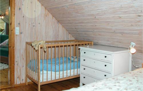 FjellerupにあるStunning Home In Glesborg With 4 Bedrooms, Sauna And Wifiのベビーベッドとドレッサー付きのベッドルーム1室