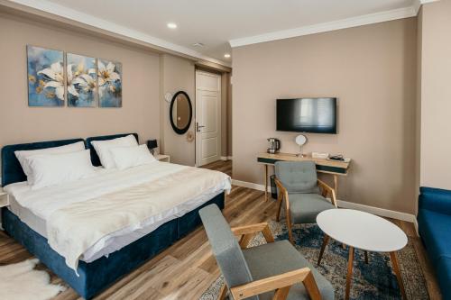 a hotel room with a bed and a desk at Pansion "Fawlty Towers" Sarajevo in Sarajevo