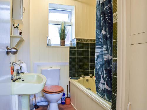 Braunston的住宿－Sheldon House，浴室配有盥洗盆、卫生间和浴缸。