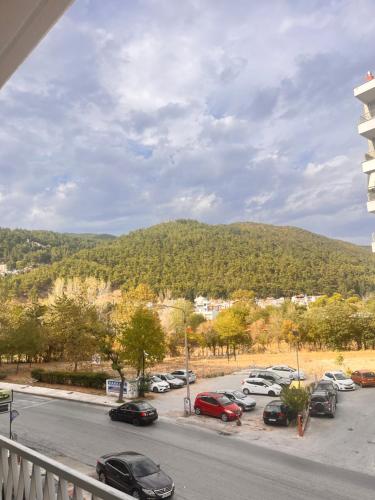 a parking lot with cars parked in front of a mountain at Άνετο διαμέρισμα - Κέντρο Ξάνθης in Xanthi