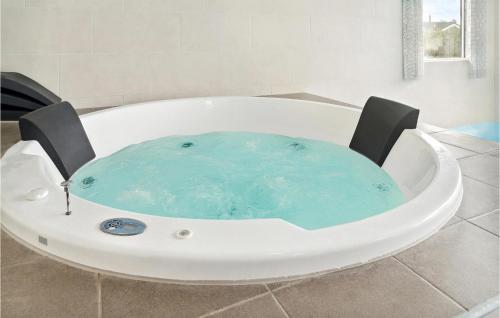 a jacuzzi tub with a chair in a bathroom at Amazing Home In Stege With Sauna in Stege