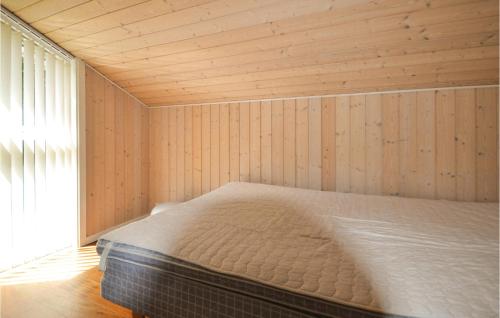 Glesborgにある3 Bedroom Stunning Home In Glesborgの木製の壁のドミトリールームのベッド1台分です。