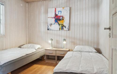 a bedroom with two beds and a painting on the wall at Stunning Home In Rdby With Wifi in Rødby