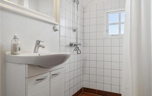 a white bathroom with a sink and a window at Stunning Home In Rdby With Wifi in Rødby
