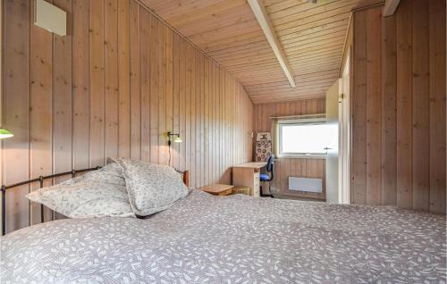 ヒュールスミンネにあるBeautiful Home In Juelsminde With Sauna, Wifi And 4 Bedroomsの木製の壁のベッドルーム1室