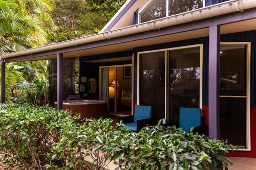 two blue chairs sitting outside of a house at Lake Russell Lakeside Retreat in Emerald Beach