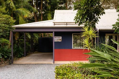 a red and blue garage with a red door at Lake Russell Lakeside Retreat in Emerald Beach