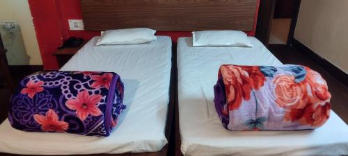 two beds in a room with white sheets at Hotel Shiva Krishna(Unit of Nandan Udyam Pvt Ltd) in Patna