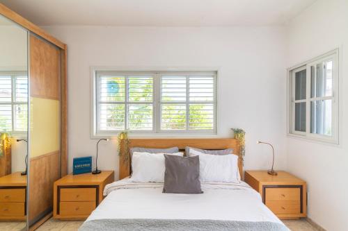 a bedroom with a large bed and two windows at Luxury Villa 6BR with Swimming Pool by Beach - Villa Costa in Rishon LeẔiyyon