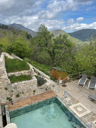 a swimming pool on a deck with a view of the mountains at Les Vignals in Arphy