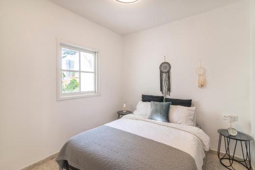 a white bedroom with a bed and a window at Luxury Villa 6BR with Swimming Pool by Beach - Villa Costa in Rishon LeẔiyyon