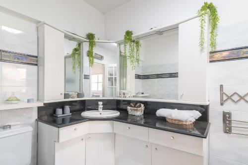 a white bathroom with a sink and a mirror at Luxury Villa 6BR with Swimming Pool by Beach - Villa Costa in Rishon LeẔiyyon