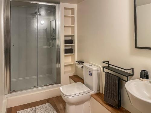 a bathroom with a shower and a toilet and a sink at Fonseca Cottage in Aberfeldy